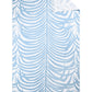 The Matouk Zebra Beach Towel Collection features a rectangular white towel with light blue zebra-stripe tropical leaves, fringe on two edges, and a folded corner revealing the reverse side.
