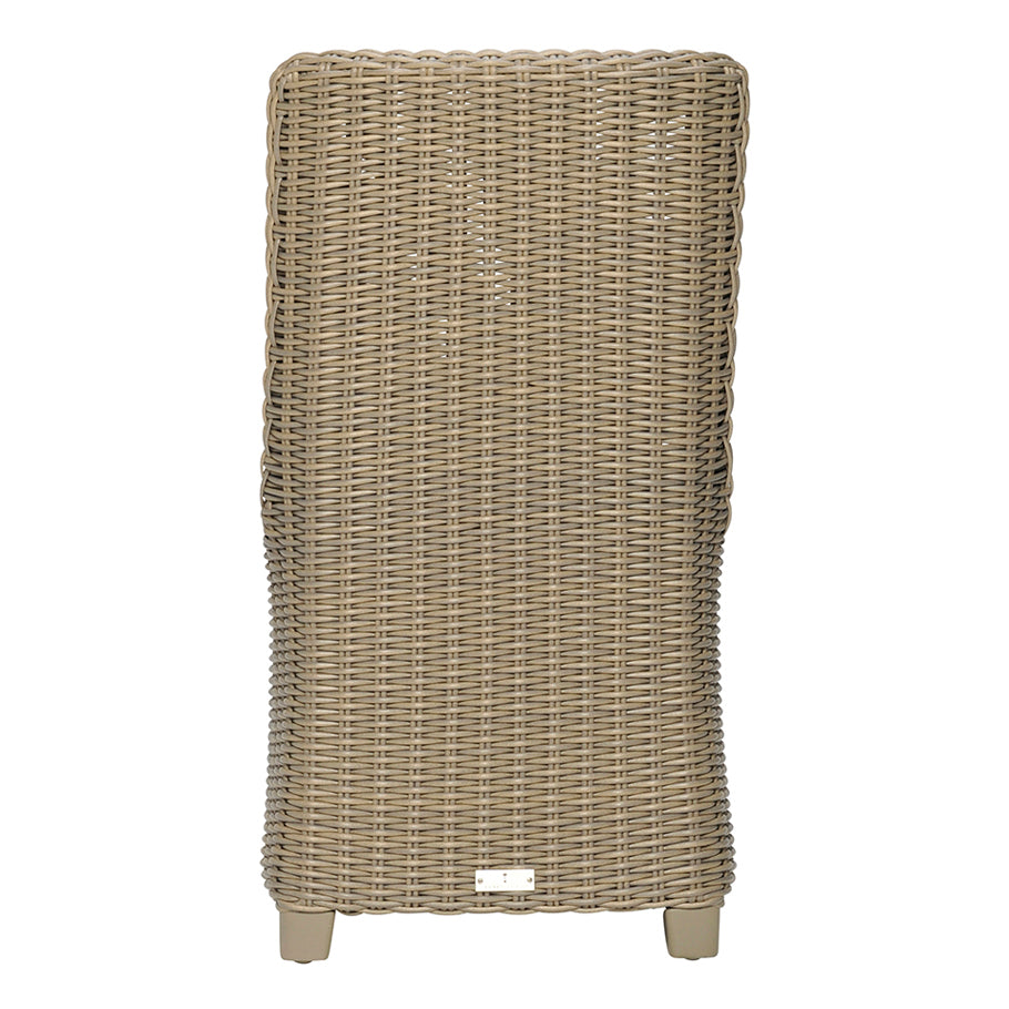 The Zeya Outdoor Dining Side Chair by Janus et Cie features a tall, rectangular wicker design with a curved backrest and four short legs—ideal for stylish, weather-resistant outdoor entertaining.