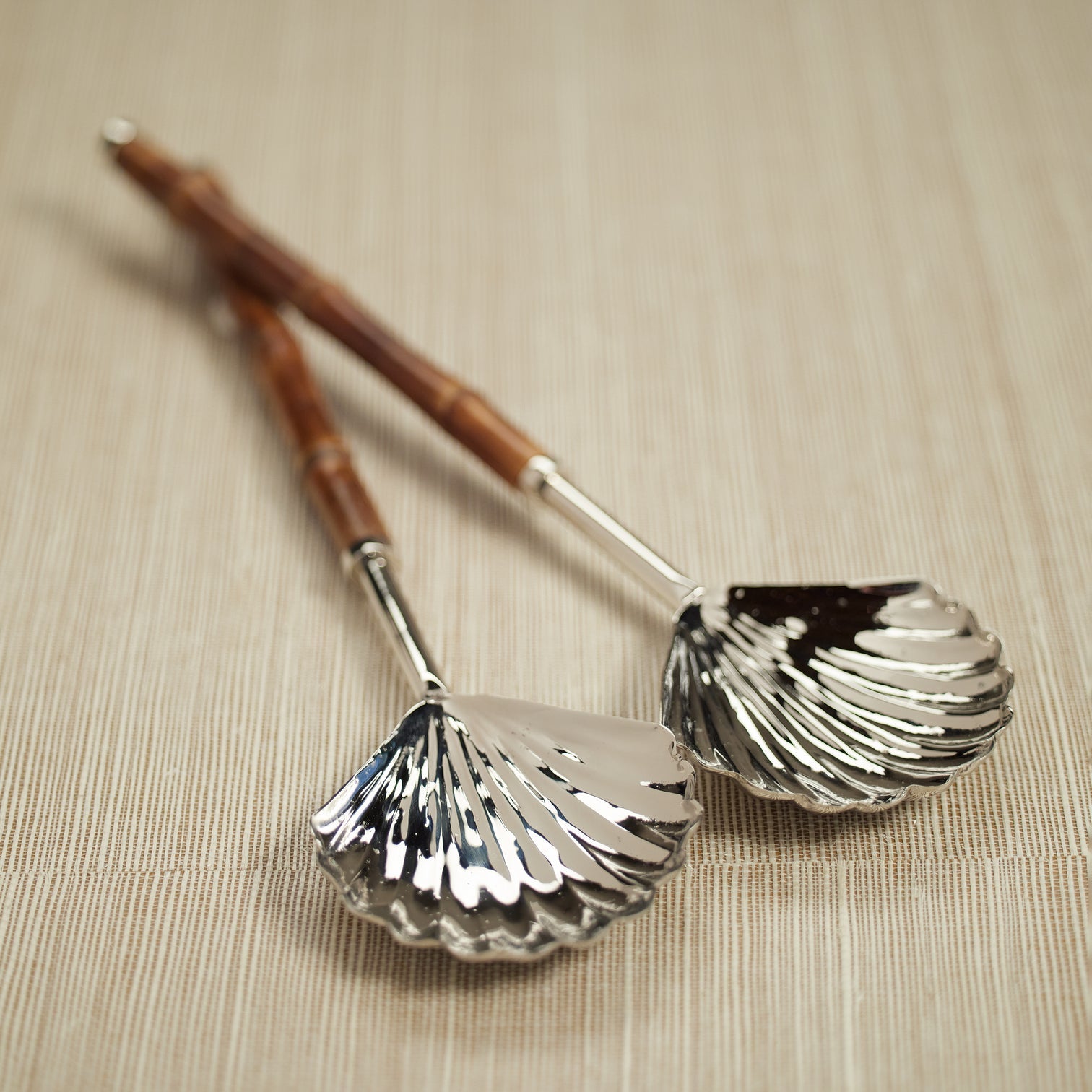 The Colony Bamboo and Nickel Serving Sets by Zodax feature two elegant serving spoons with shell-shaped nickel bowls and bamboo handles—an ideal addition to elevate your serving collection.
