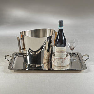 The Manetta Polished Nickel Tray Collection by Zodax displays a metal ice bucket, a wine bottle in a marble holder, and an empty wine glass on a light surface.