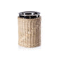 A glass jar from the Zodax Palmier Barware Collection, featuring a shiny metal lid and hand-woven rattan wrap, stands upright against a white background in this elegant display.