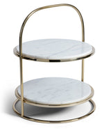 The Zodax Cake Stand features two round white marble tiers and a gold metal frame with a handle-style top—perfect for displaying desserts at gatherings.