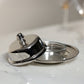 The Zodax Parisian Butter Dish, a small silver piece with a nickel-finished cover and beaded edge detail, rests partially open on a marble surface.