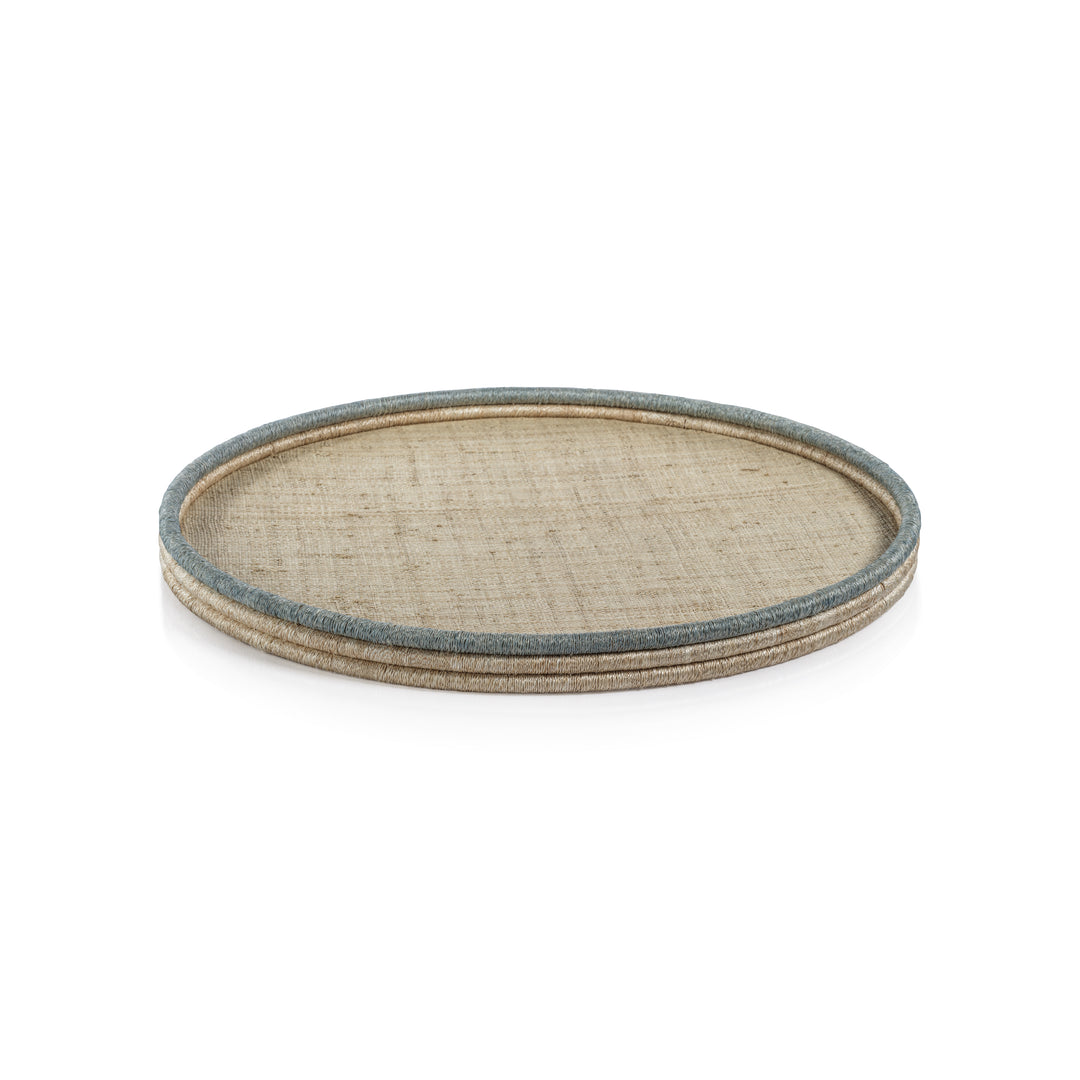 The La Côte Coiled Round Tray Collection by Zodax features a light rattan serving tray with a blue-gray rim, ideal for coastal décor. Shown on a white background.