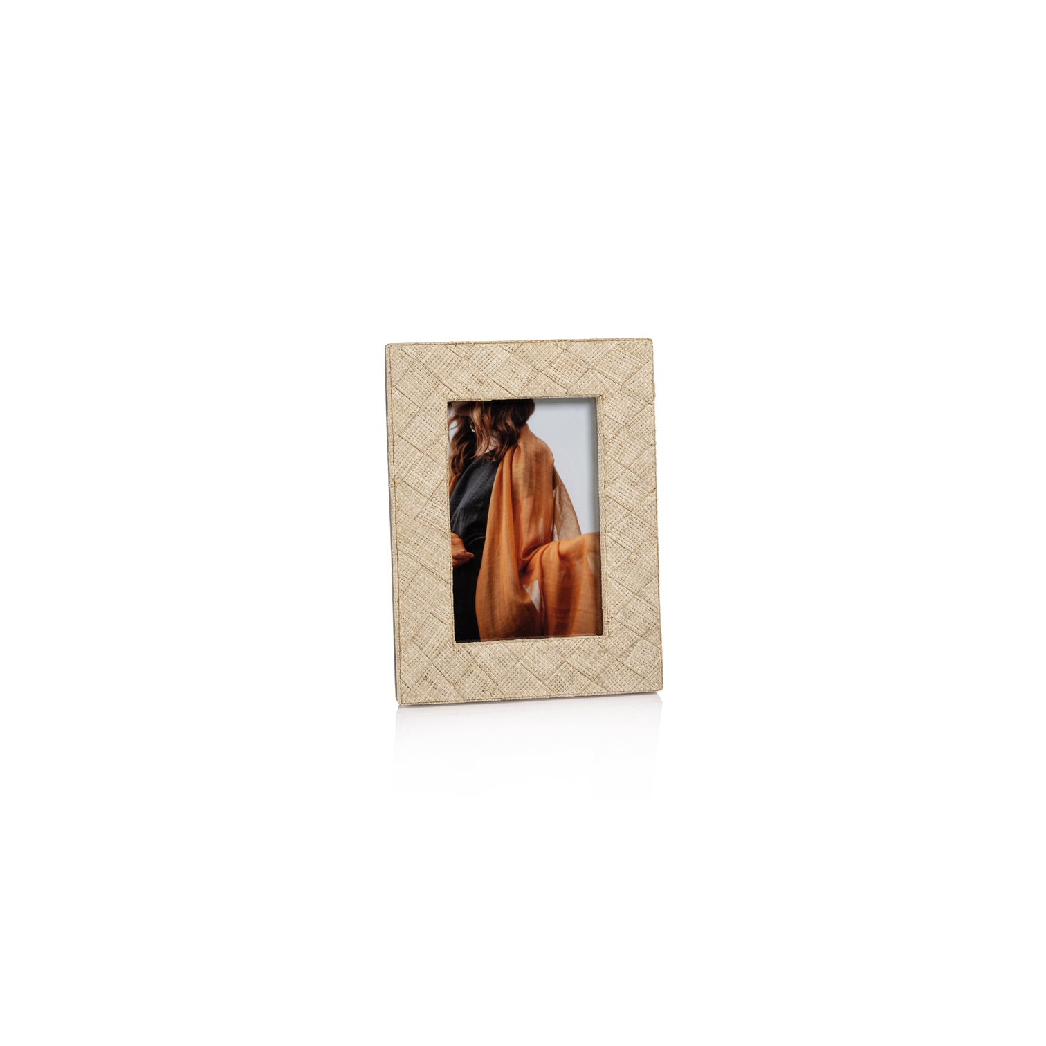 The La Bocca Frame Collection by Zodax features a natural, chic beige photo frame crafted from woven raffia, shown displaying a partial image of a long-haired person in orange against a plain white background.