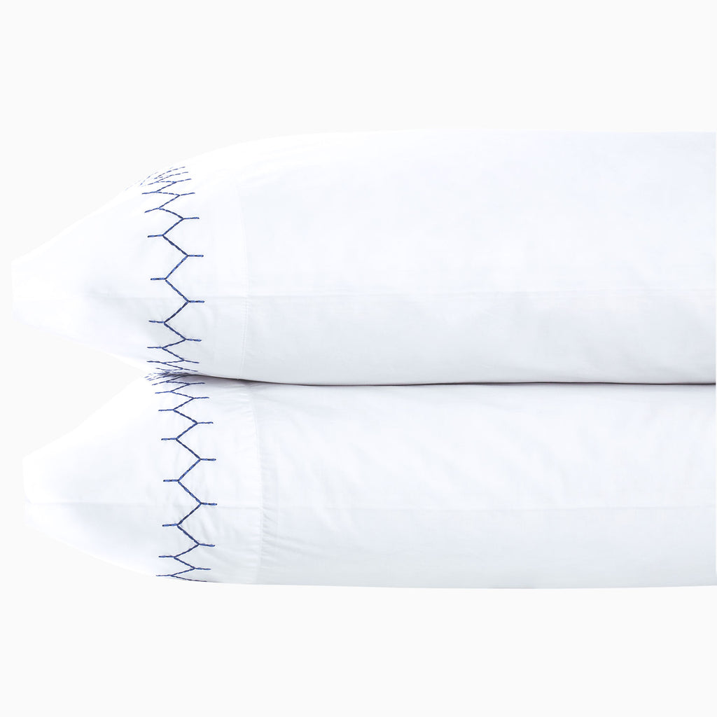 Two white pillows from the John Robshaw Stitched Indigo Bedding Collection, each featuring a blue stitched pattern along one edge, are stacked against a plain white background.