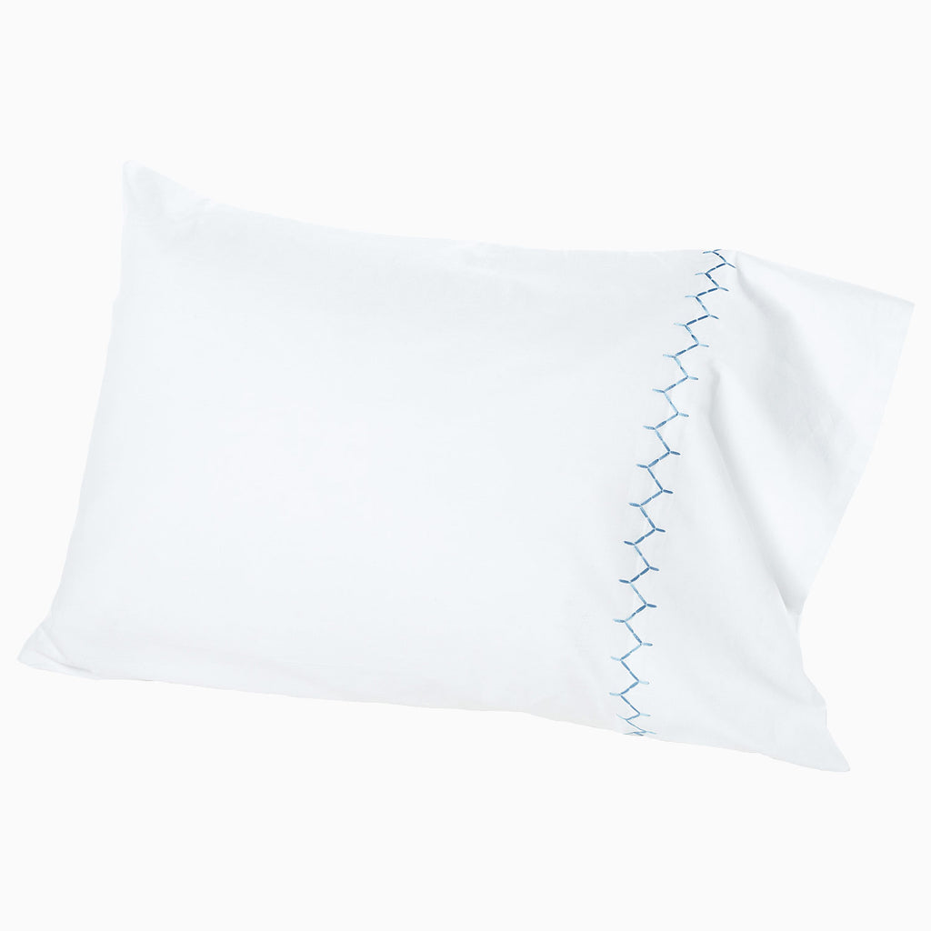 The John Robshaw Stitched Light Indigo Sheet Set features soft organic cotton with a blue decorative stitched pattern along one edge, presented on a plain white background.