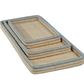 The Zodax La Côte Coiled Rectangular Tray Collection features three abaca fiber trays in assorted sizes, stacked together with light beige bases and light gray-edged rims.
