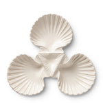 The Aerin Shell 3-Bowl Dish is a white ceramic serving platter with three shell-shaped compartments in a triangle, ideal for presenting seafood.