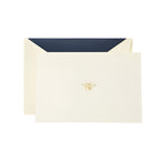 Crane's Bee Classic Card Set includes an ecru card and envelope with a gold bee emblem and dark blue lining, all set on a white background—ideal for sending thoughtful handwritten notes.