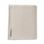 The Garmercy Throw by Alicia Adams Alpaca is a neatly folded, beige and cream striped baby alpaca blanket with a fabric label—luxurious home decor perfect for elevating any space.