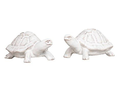 The Clever Creatures Turtle Salt and Pepper Set by Juliska features two white ceramic turtles with textured shells, positioned side by side and believed to bring wisdom and good luck—an ideal accent for entertaining enthusiasts.