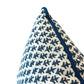 Close-up of the Burma White Indigo Outdoor Pillow by Associated Design, showcasing a blue leaf-like pattern and piped edge on a white background, crafted from premium materials against a plain backdrop.