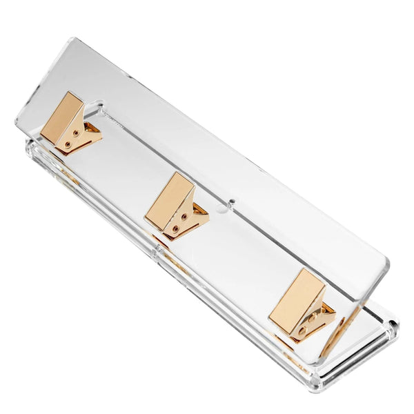 The Russell & Hazel Acrylic Signature Hole Punch is a clear, rectangular acrylic tray featuring gold-toned hardware with three evenly spaced rectangular clips attached to the base.