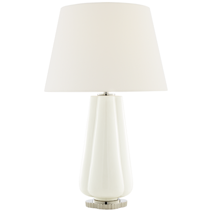 The Penelope Table Lamp Collection by Visual Comfort showcases a white ceramic base, simple white shade, and metallic accents for a modern touch and soft ambient lighting in any space.