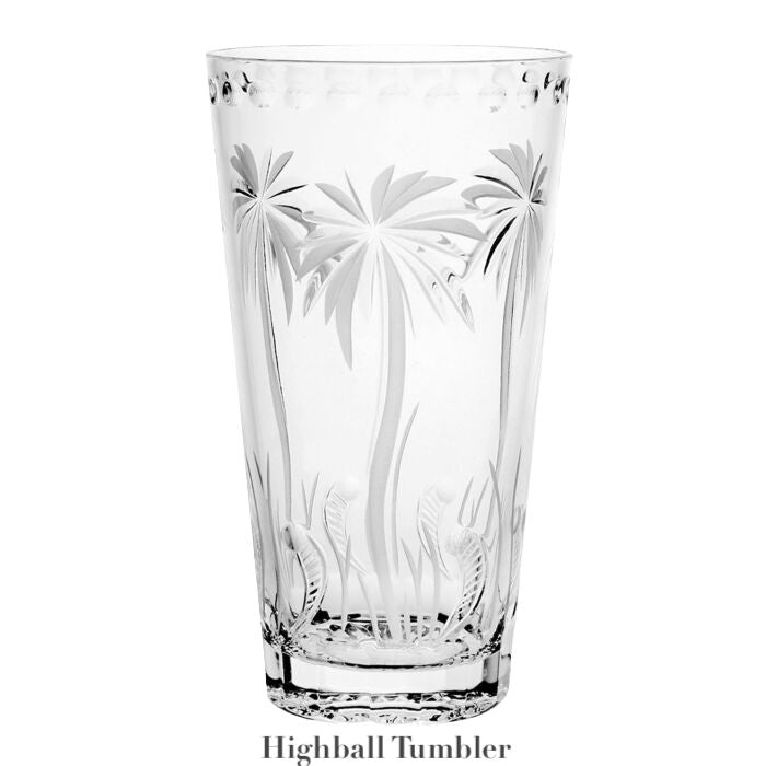 The Alexis Collection highball tumbler by William Yeoward Crystal is handmade, clear crystal with etched palm tree and grass motifs, shown on a white background.
