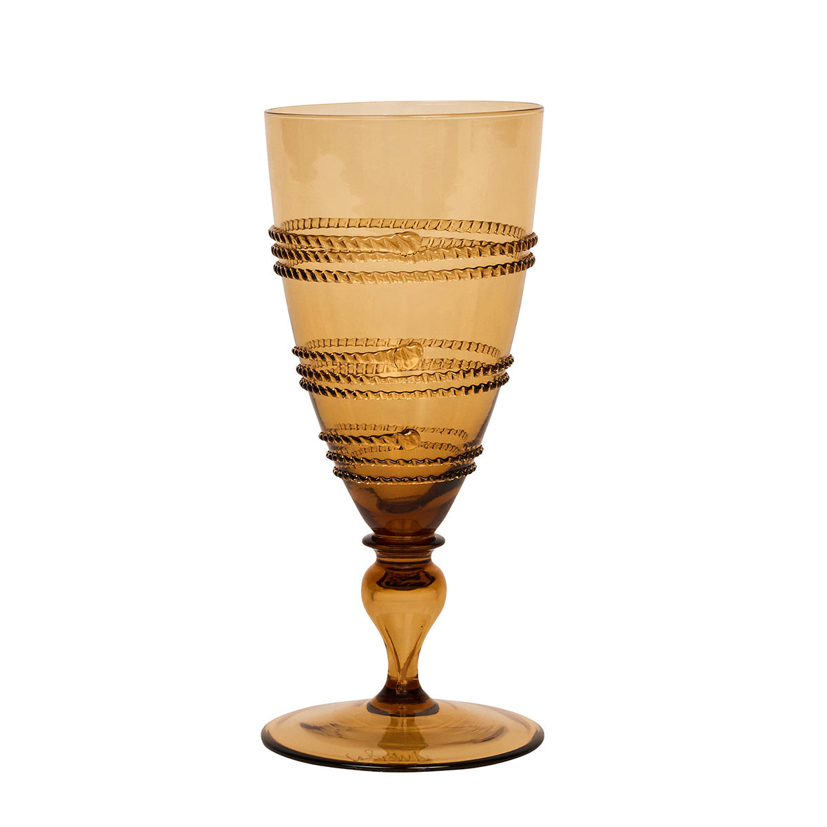 The Juliska Ella Drinkware Collection features an amber-colored glass goblet adorned with a decorative spiral pattern around the bowl, highlighting exquisite artisan craftsmanship against a white background.