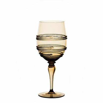 A yellow-tinted wine glass from Juliska’s Ella Drinkware Collection features a graceful spiral decorative pattern around the bowl and is set against a plain white background. This exquisite piece of mouth-blown glassware showcases the collection’s artisanal craftsmanship, blending elegance and handcrafted charm for any sophisticated table setting.