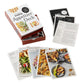 An open box labeled “The New York Times Cooking Appetizer Deck” by Penguin Random House displays several illustrated recipe cards, each featuring vibrant images of party appetizers and detailed cooking instructions inspired by NYT Cooking.