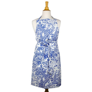 A mannequin displays a Caspari Apron Collection cotton apron in white, featuring an intricate blue pastoral and garden-themed pattern, tied at the waist.