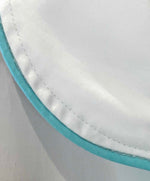 Close-up of a white cotton sateen fabric edge with blue trim and visible stitching, highlighting the luxury sleep quality of the Haute Home Smart Pajama Pant Set.