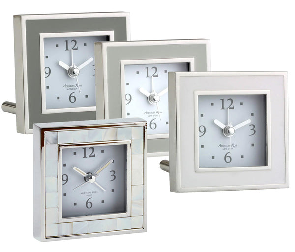 The Addison Ross Silver Square Alarm Clock Collection by Addison Ross features five square desk clocks with gray dials and diverse frame designs, such as glossy, metallic, and matte finishes.