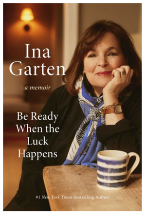 Book cover of "Be Ready When the Luck Happens: A Memoir" by Penguin Random House, showing Ina Garten seated at a table with a striped mug, smiling at the camera.