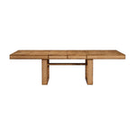 The Dariel Extension Dining Table by Made Goods features a rectangular wooden top with two wide pedestal legs, a horizontal support beam, and natural burl patterns for added texture.