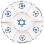 The Herend Fish Scale Seder Plate, Blue, showcases a stunning design with hand-painted white and blue elements, Hebrew text, and a Star of David centerpiece. Crafted from Herend porcelain, it features six sections for the symbolic foods.