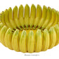 The Bananas From Madeira Serveware Collection by Bordallo Pinheiro features a bowl shaped like upright yellow bananas, making a striking tropical centerpiece for your collection.