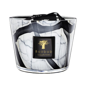 The Baobab Collection Stones Marble Candle by Baobab comes in a hand-blown grey marble-patterned black and white glass holder, with a black and gold label on the front and a black ribbon tied on top.