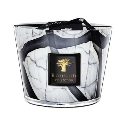 The Baobab Collection Stones Marble Candle by Baobab comes in a hand-blown grey marble-patterned black and white glass holder, with a black and gold label on the front and a black ribbon tied on top.