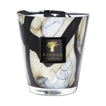 The Baobab Collection Stones Marble Candle by Baobab comes in a hand-blown glass holder with black, white, and beige marbled patterns, finished with a black label featuring a gold tree logo.