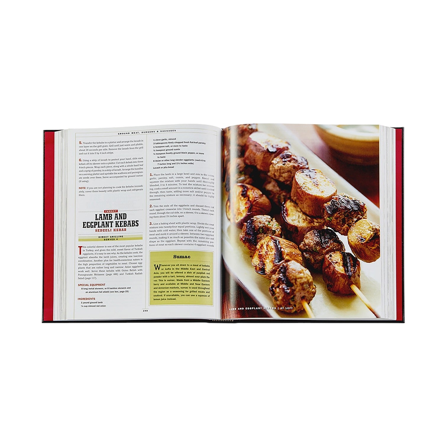 An open copy of The Barbecue Bible by Graphic Image shows a lamb and eggplant kebab recipe on the left and a close-up of skewered kebabs on the right—ideal inspiration for discovering new barbecue dishes.
