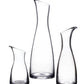 Three upright Barre Carafe Collection vessels by Simon Pearce, in clear handmade glass with slanted rims and varying heights, displayed against a white background.