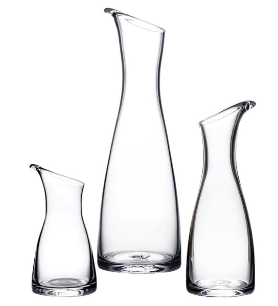 Three elegantly designed pieces from the Simon Pearce Barre Carafe Collection stand side by side against a white background, exemplifying the artisanal craftsmanship of Simon Pearce.