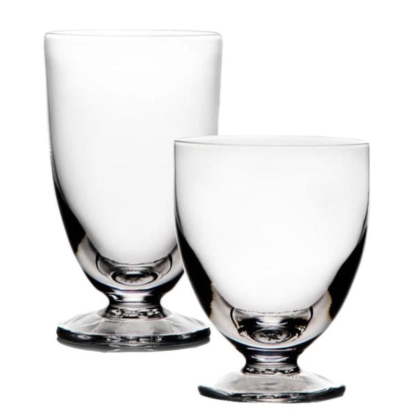 Two clear glass goblets with rounded bowls and flat, sturdy bases. Expertly crafted by Simon Pearce as part of the Barre Collection, one goblet is taller than the other, epitomizing modern drinkware elegance.