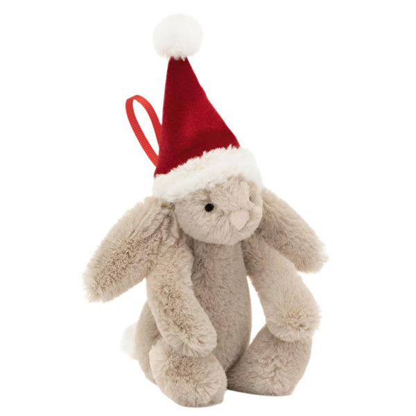 The Jellycat Bashful Christmas Bunny Ornament features a praline-colored stuffed bunny wearing a festive berry velour Santa hat, accented with white trim and a pom-pom, making it an ideal decoration for the holiday season.