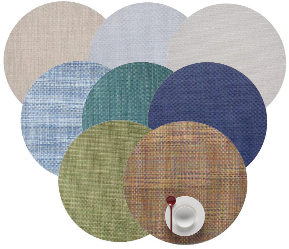Eight Chilewich Round Placemats made from phthalate-free Terrastrand yarns overlap in a circle, with a white cup, saucer, and red spoon placed on the bottom right placemat.