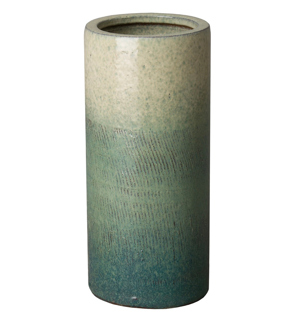 The Bayside Glaze Umbrella Stand by Emissary is a cylindrical ceramic piece with subtle textured lines and a glossy gradient finish—beige at the top, bayside green in the middle, and blue at the base.
