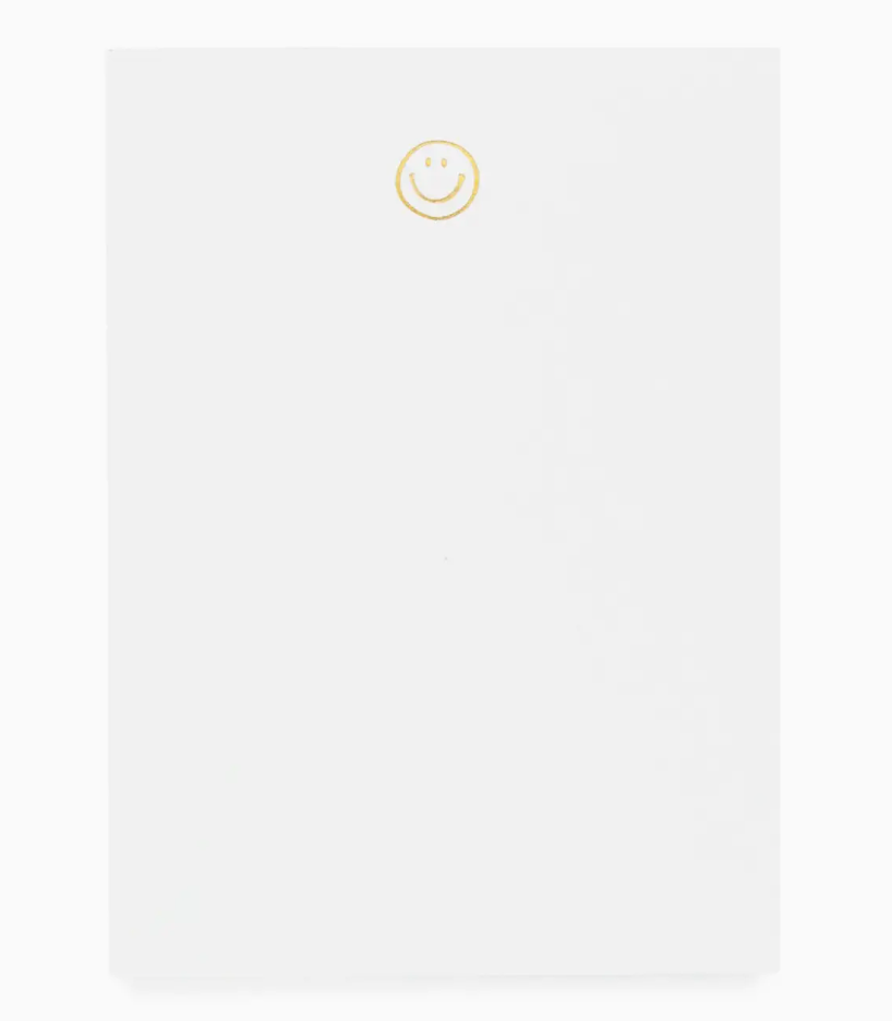 The Sugar Paper Mini Notepad, Smiley, features a petite white design with a cheerful yellow smiley at the top—perfect for brightening your notes.