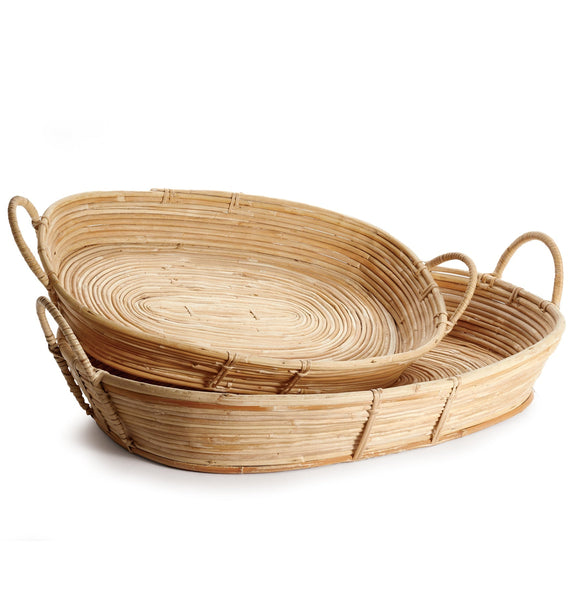 The Napa Home Cane Rattan Tray Collection by Napa Home & Garden features two oval trays with a youthful look, one nested inside the other and equipped with practical handles for easy carrying.