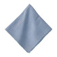 The Berry Trim Napkin Collection by Juliska features light blue linen napkins with decorative embroidered trim, shown against a white background.