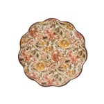 The Willa Dinnerware Collection by Juliska features round scalloped chargers with a delicate edge and an intricate romantic floral pattern in red, yellow, green, and brown on a white background.