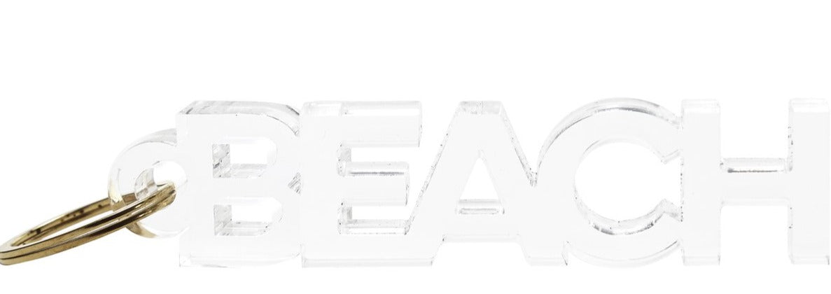 Add a touch of style to your keys with the Acrylic Key Chain Collection by Tara Wilson Designs, featuring “BEACH” in cut-out capital letters on clear acrylic and finished with a gold metal key ring.