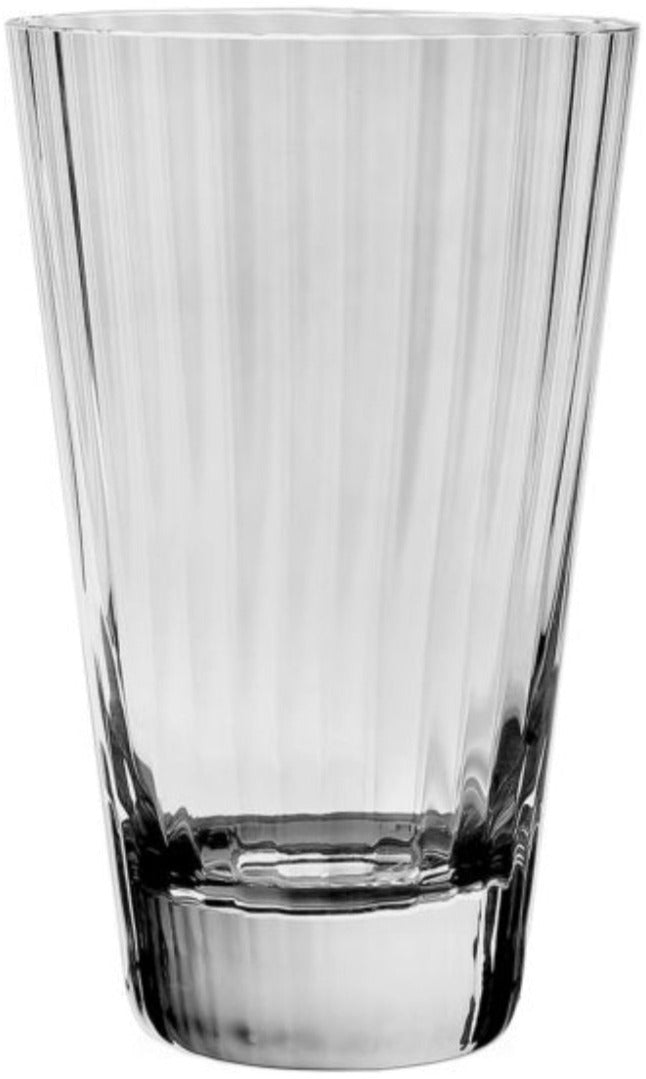 A clear, empty Corinne Collection drinking glass by William Yeoward Crystal, featuring a vertical optic pattern, stands upright against a plain white background.