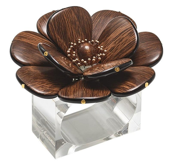 The Kim Seybert Begonia Napkin Ring, echoing natural beauty, showcases intricate petals gracefully mounted on a clear rectangular base—an exquisite addition to any table setting.