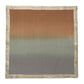 The Kim Seybert Dip Dye Napkin Set features square gradient fabric in autumn hues with brown, gray, and teal transitioning vertically and a textured light brown edge, creating the perfect seasonal effect.