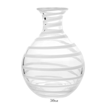 The Bella Bianca Carafe Collection by William Yeoward Crystal features a clear glass carafe with a round base, narrow neck, diagonal white stripes, and 50-oz capacity—perfect for wine. Proposition 65: may expose you to chemicals causing harm in California.