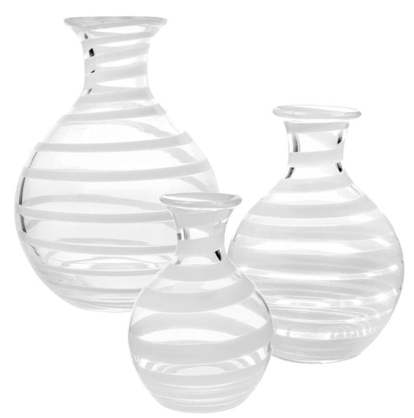 The William Yeoward Crystal Bella Bianca Carafe Collection features three clear glass vases with horizontal white stripes, resembling elegant carafes, varying in size and displayed side by side on a white background.
.